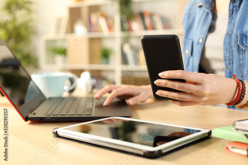 Student girl hands using multiple devices at home