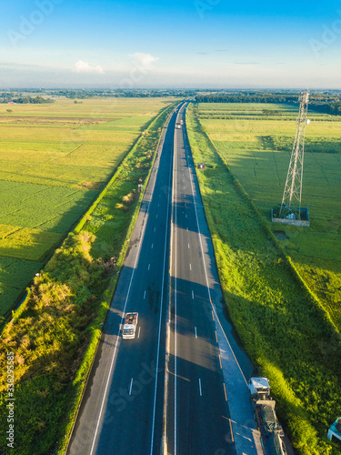 Aerial of a major Philippine highway with green fields on either side. photo