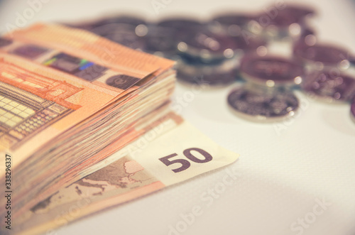 50 euro banknotes on a background of coins. Business concept. Image is tinted.