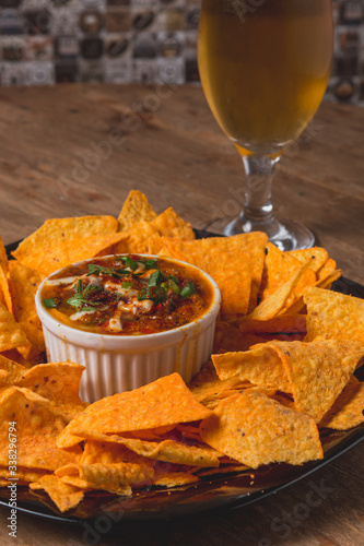 Comida de boteco brasileira nachos mexicanos com molhos servido em tigela em balcão de boteco photo