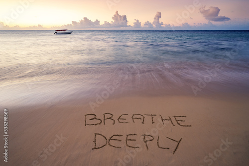 Handwritten Breathe deeply on sandy beach at sunset,relax and summer concept,Dominican republic beach.