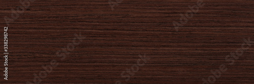 Veneer background in dark brown color for your new design view. Natural wood texture, pattern of a long veneer sheet.