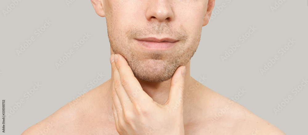 Fototapeta premium Man hold chin. Hand near male face. Think concept. Happy person. Close up. Casual home skin care routine. Healthcare facial treatment. Cute people standing. Mirror interesting