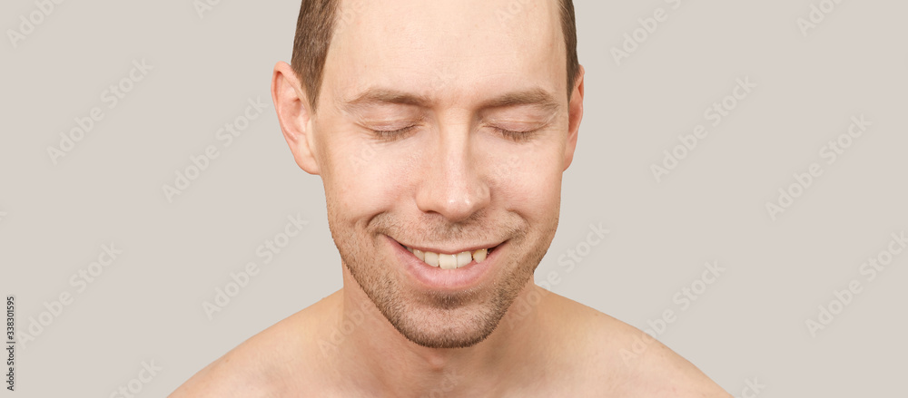 Obraz premium Smiling white man. Beauty cosmetology portrait. Closed eyes. Smile male person. Dream about travel. Clean skin procedure. Laugh handsome adult. Beige background. Calm relax concept.