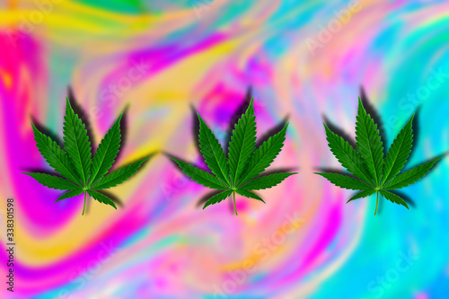 Фотография green cannabis leaf on a blurred holographic psychedelic background