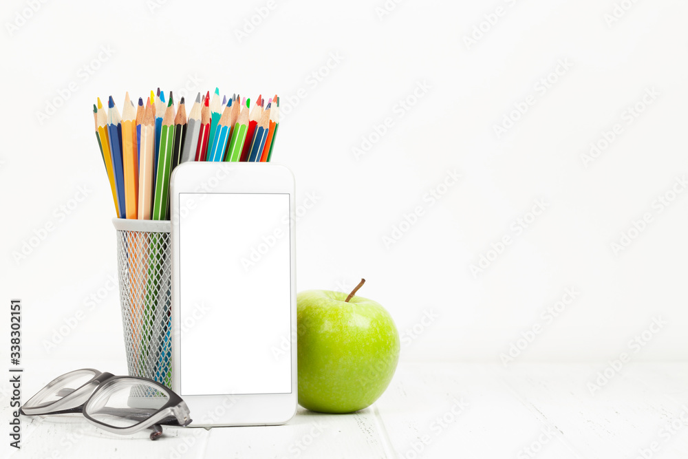 Naklejka premium Workplace with smartphone, supplies and apple