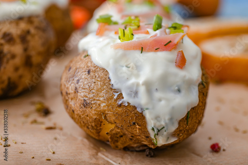 Tasty baked potato with sour cream on table, closeup