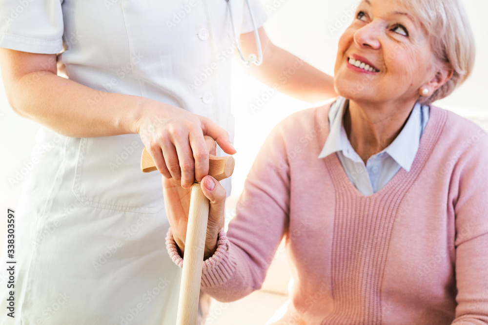 Obraz premium Close-up of person touching hand of senior woman. Home assistance concept. Elderly female hand holding hand of young caregiver at nursing home.Geriatric doctor or geriatrician concept.
