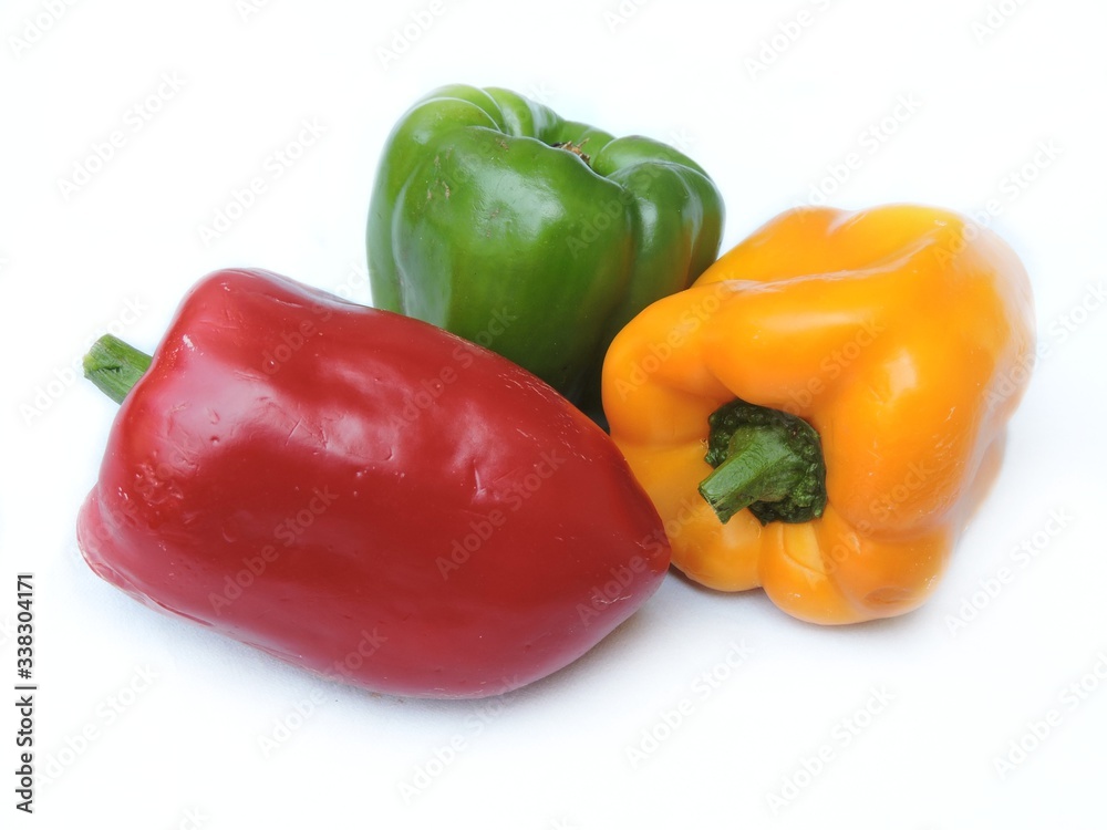 Red, yellow and green bell peppers in isolated white background. 
