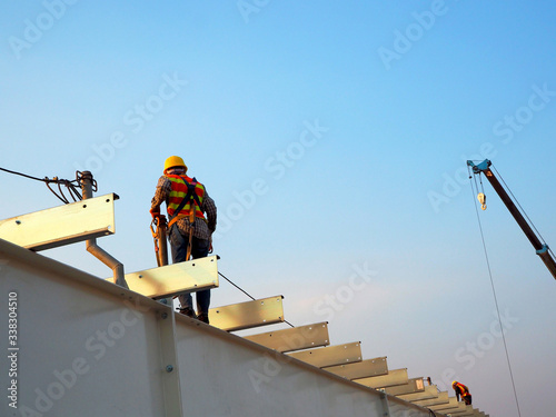 Man Working on the Working at height on construction site with blue sky