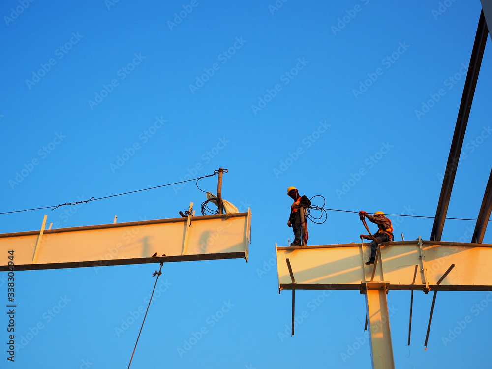 Man Working on the Working at height on construction site with blue sky Man Working on the Working at height on construction site with blue sky