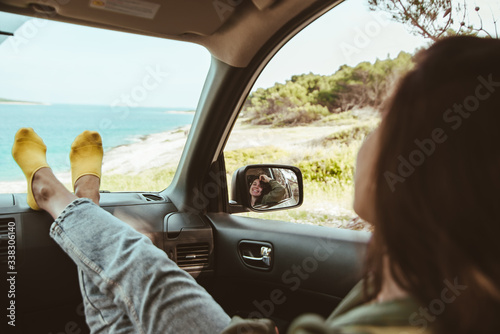 Wallpaper Mural woman sitting in car looking at sea. reflection in mirror Torontodigital.ca