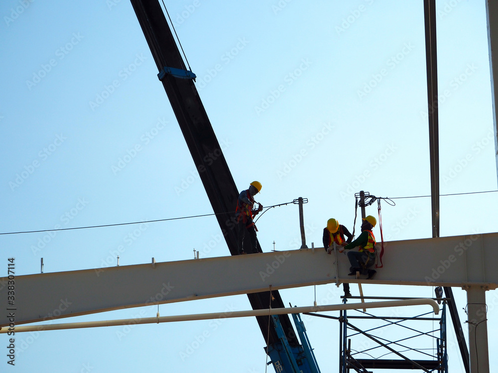 Man Working on the Working at height on construction site with blue sky Man Working on the Working at height on construction site with blue sky