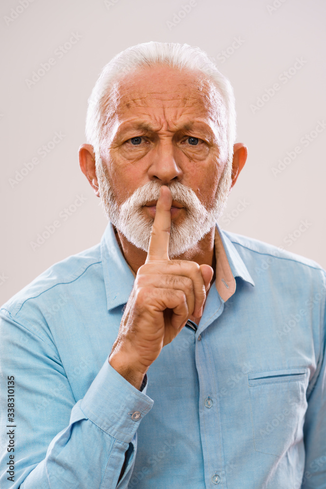 Portrait of angry senior man who wants silence.