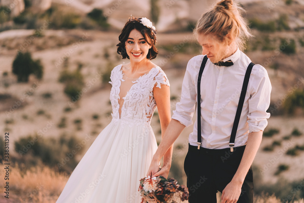 Couple holding hands and smiling bride in Cappadocia