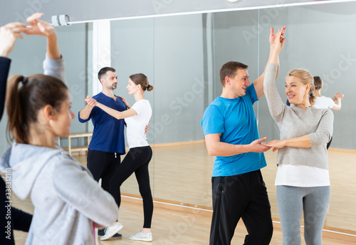 Mature dancing couple during group class