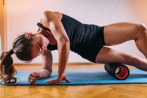 Woman Massaging Legs with Foam Roller photo