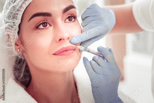 Client having injection into upper lip enjoying beauty treatment