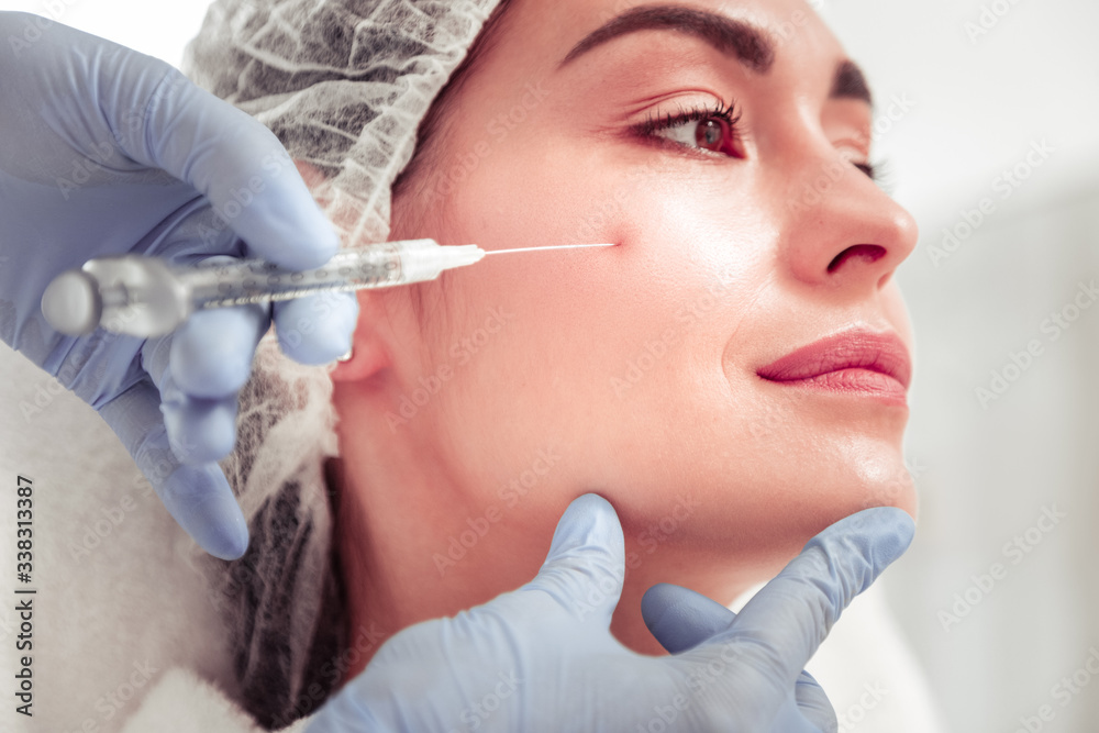 Cosmetologist touching face of client doing beauty shot Cosmetologist touching face of client doing beauty shot