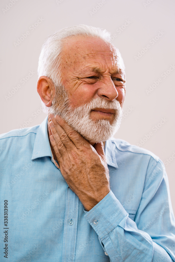 Portrait of senior man who is having pain in neck glands. Portrait of senior man who is having pain in neck glands.