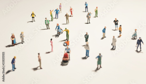 Top view of people (miniature toys) with long shadows keep distance away in public during sunrise or sunset.Social distancing / COVID-19 coronavirus outbreak spreading concept.