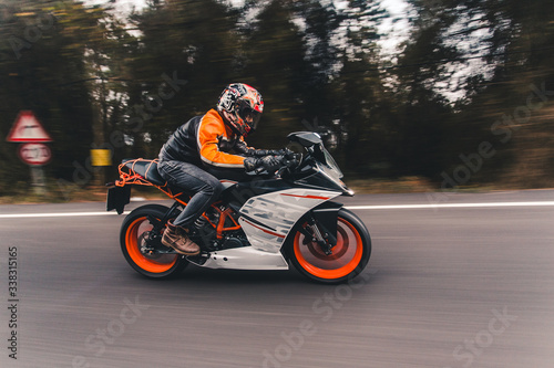 Driving an orange color motorcycle on the road