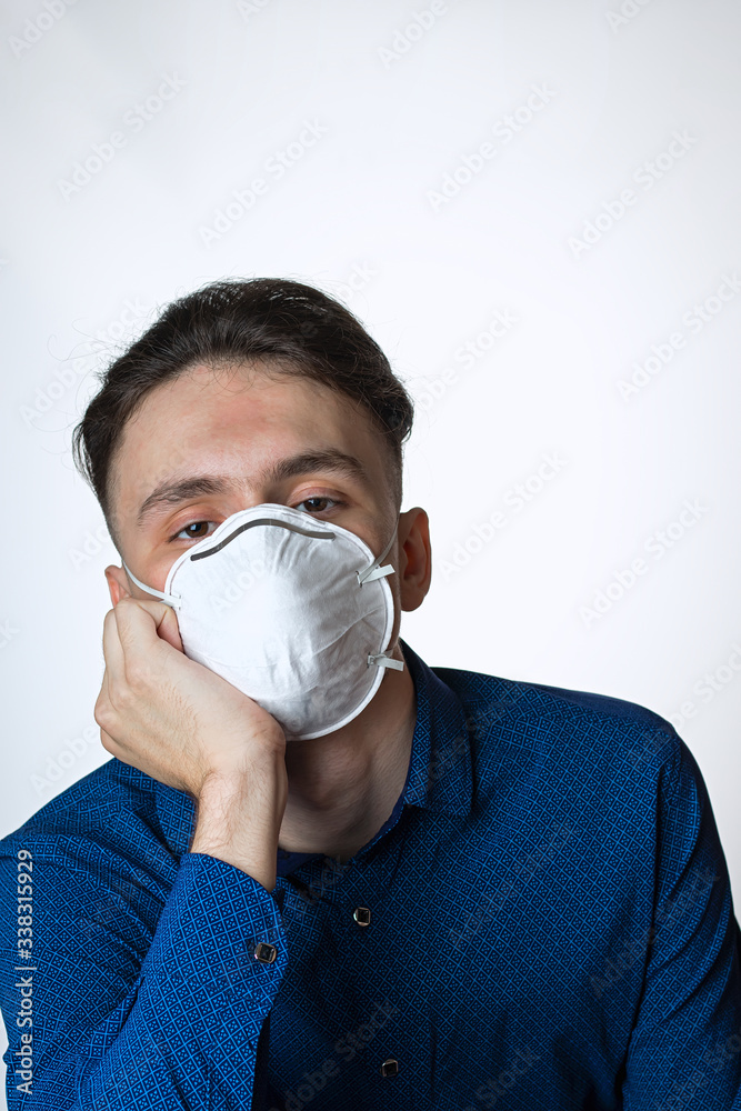 Portrait of a young man wearing a protective mask against coronavirus is quickly overcome isolated on a white background Portrait of a young man wearing a protective mask against coronavirus is quickly overcome isolated on a white background