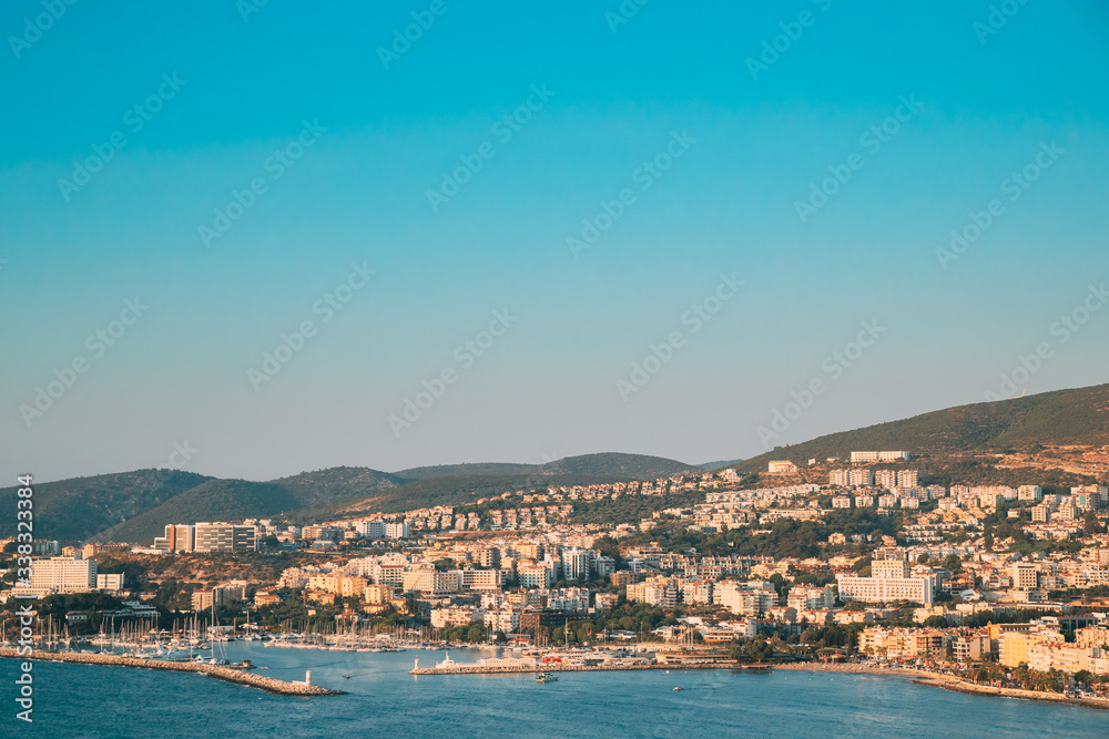 Kusadasi, Aydin, Ayd n Province, Turkey. Waterfront And Kusadasi Cityscape In Sunny Summer Evening. Scenic View Of Kusadasi Skyline At Aegean Coast, Turkey