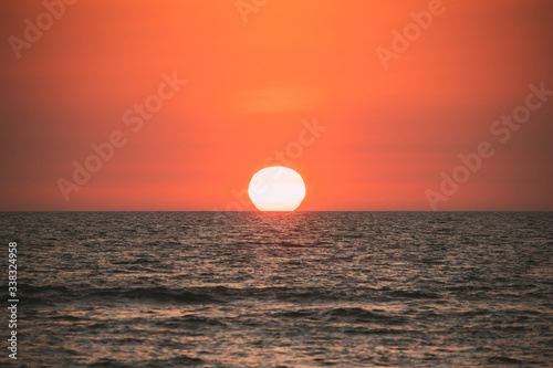 Natural Color Sunset Sunrise Sky Over Sea. Seascape With Shining Setting Sun On Sea Horizon