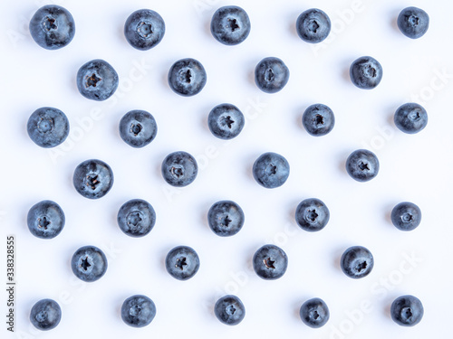 Looking down at blueberries laid out in a geometric pattern on a white background 