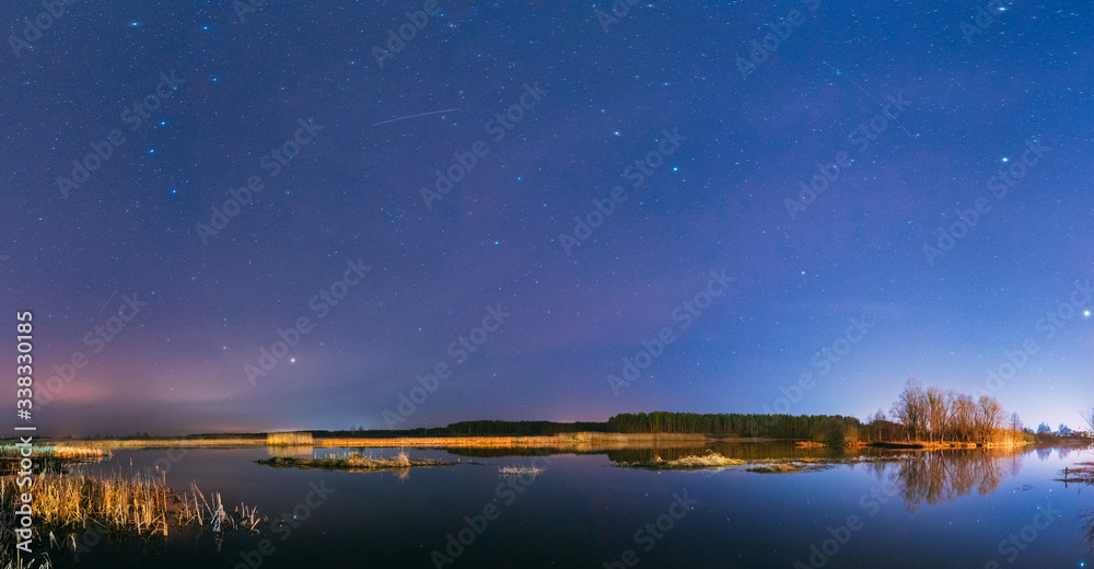 Belarus, Eastern Europe. Night Sky Stars Above Countryside Landscape With River. Natural Starry Sky Above Lake Pond In Early Spring Night. Russian Nature. Panorama, Panoramic View