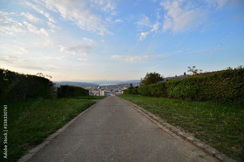 Footpath in the Waid with a view of the city of Zurich Switzerland in the morning with the Alps in the background