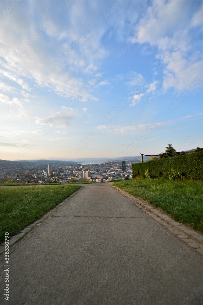 Footpath in the Waid with a view of the city of Zurich Switzerland in the morning with the Alps in the background