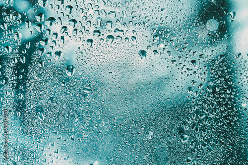 Drops Of Water Or Rain On Wet Glass Background. Moody Photo In Fresh Blue Color