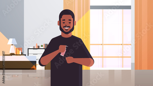 african american man applying antibacterial spray covid-19 virus bacteria disinfection stop coronavirus pandemic quarantine concept living room interior horizontal portrait vector illustration