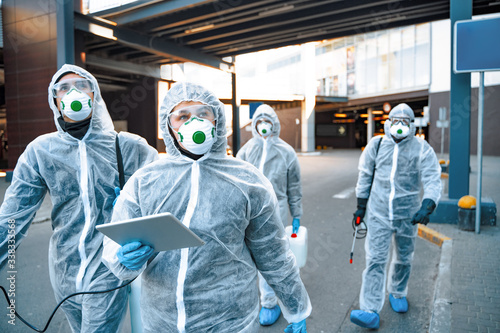 Healthcare workers wearing hazmat suits working together during an outbreak in the city
