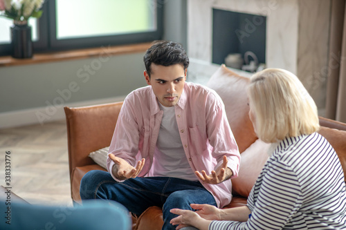 Young man in a pink shirt looking involved