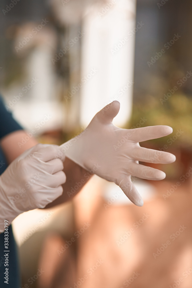 Female surgeon or nurse wearing a sterile suit putting on sterile