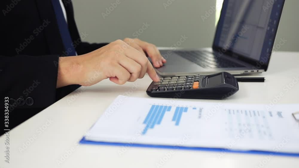 Manager Using Calculator Managers are using a check calculator to see the numbers that the staff ...