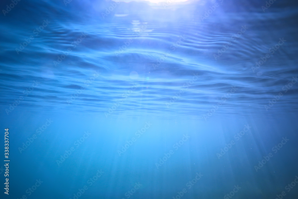 ocean water blue background underwater rays sun / abstract blue background nature water