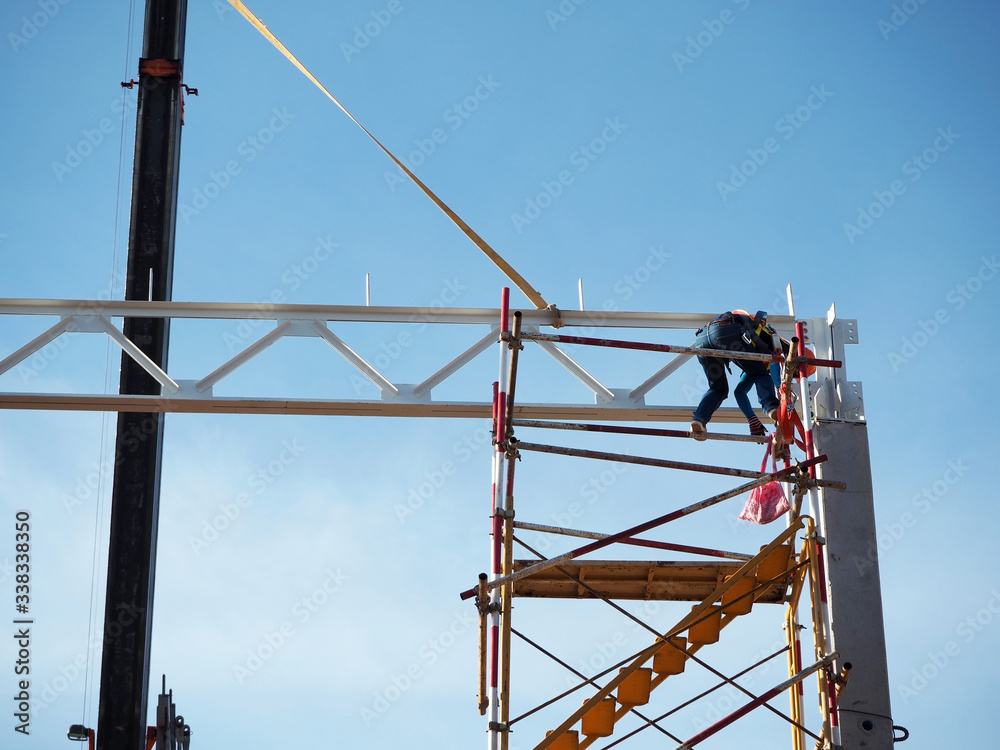 Man Working on the Working at height on construction site with blue sky