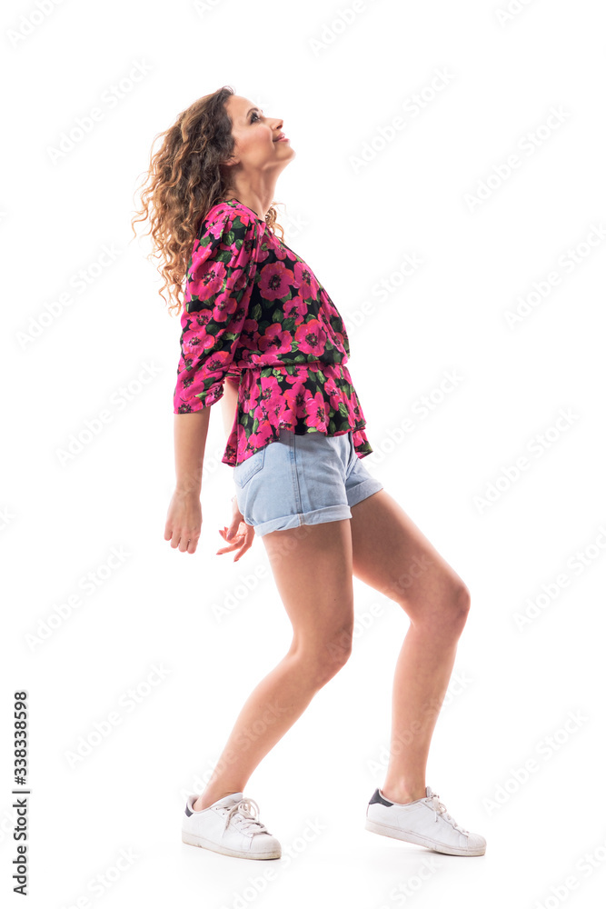 Naklejka premium Young curly hair girl fashion model in delicate relaxed posture looking up and modelling. Full body isolated on white background. 