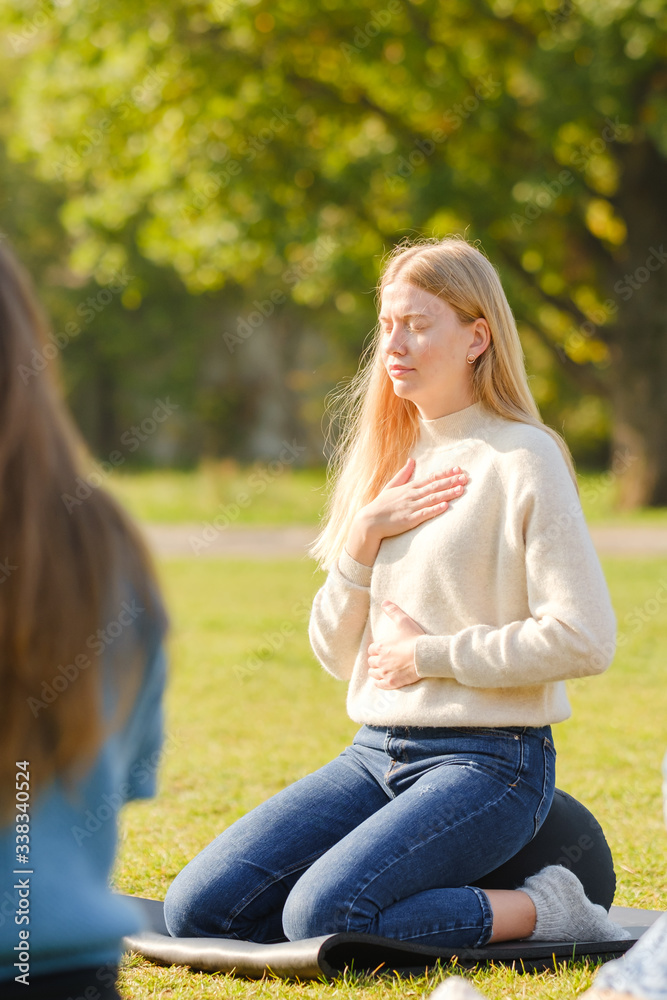 woman practices yoga and meditates in the lotus position in the park woman practices yoga and meditates in the lotus position in the park