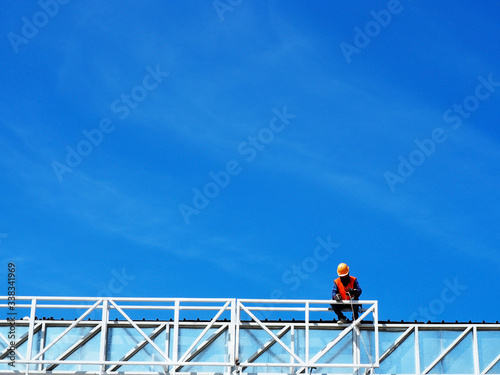 Man Working on the Working at height on construction site with blue sky