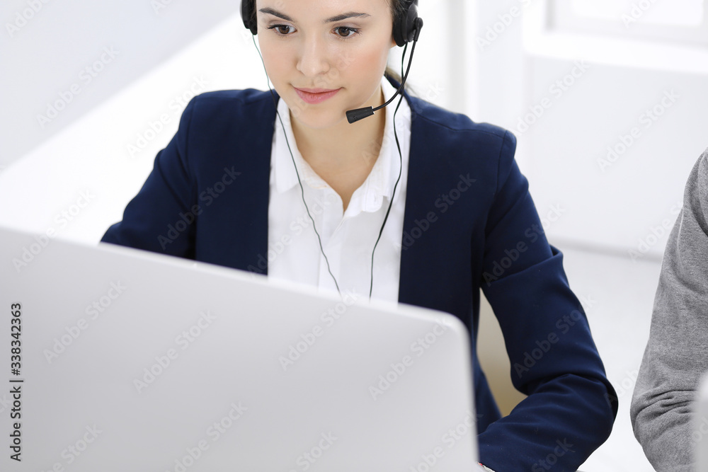 Call center. Beautiful woman sitting and working in headset at customer service office. Business concept Call center. Beautiful woman sitting and working in headset at customer service office. Business concept