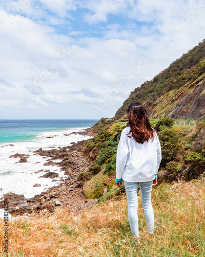 Woman, Beach sea waves and mountain rocks coastline. urquoise ocean, white sand, road trip. Travel, driving, road trip, holiday, vacation, journey, paradise. Great Ocean Road. Melbourne, Australia. © Jam Travels