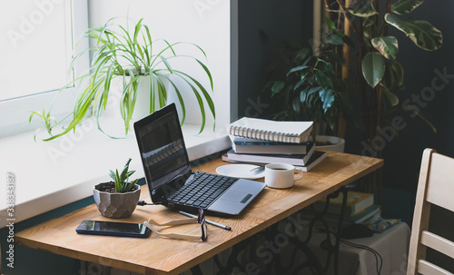 Workplace of man desk books laptop home interior. The concept of distance learning or online learning.