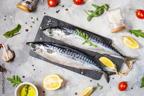 Fresh raw mackerel with lemon and spices on a concrete background. photo