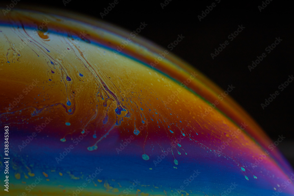 Fotografía macro de una gran burbuja de jabón donde se pueden observar los colores arco iris por la difracción de la luz blanca 
