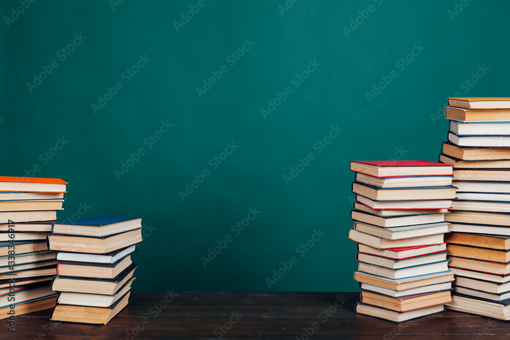 many stacks of educational books to teach in the school library on a green background many stacks of educational books to teach in the school library on a green background